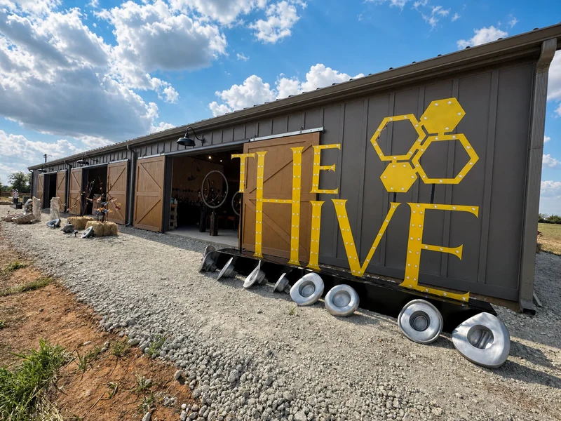 The Hive’s yellow sign and open barn doors under a blue Texas sky