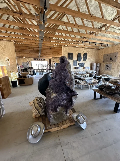 Large amethyst geode surrounded by collected objects at The Hive